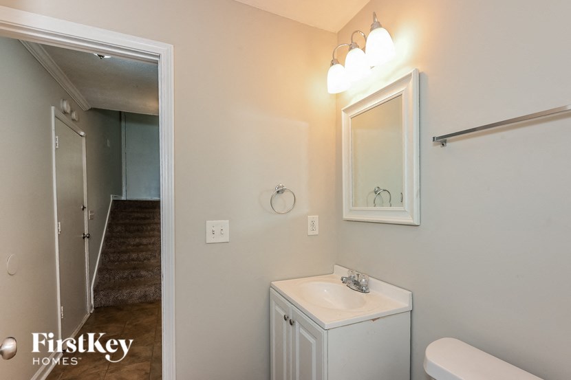 a bathroom with a sink and a mirror and a staircase