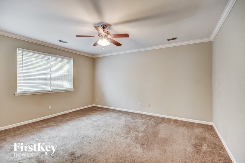 a bedroom with a ceiling fan and a window
