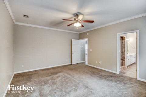 a living room with carpet and a ceiling fan