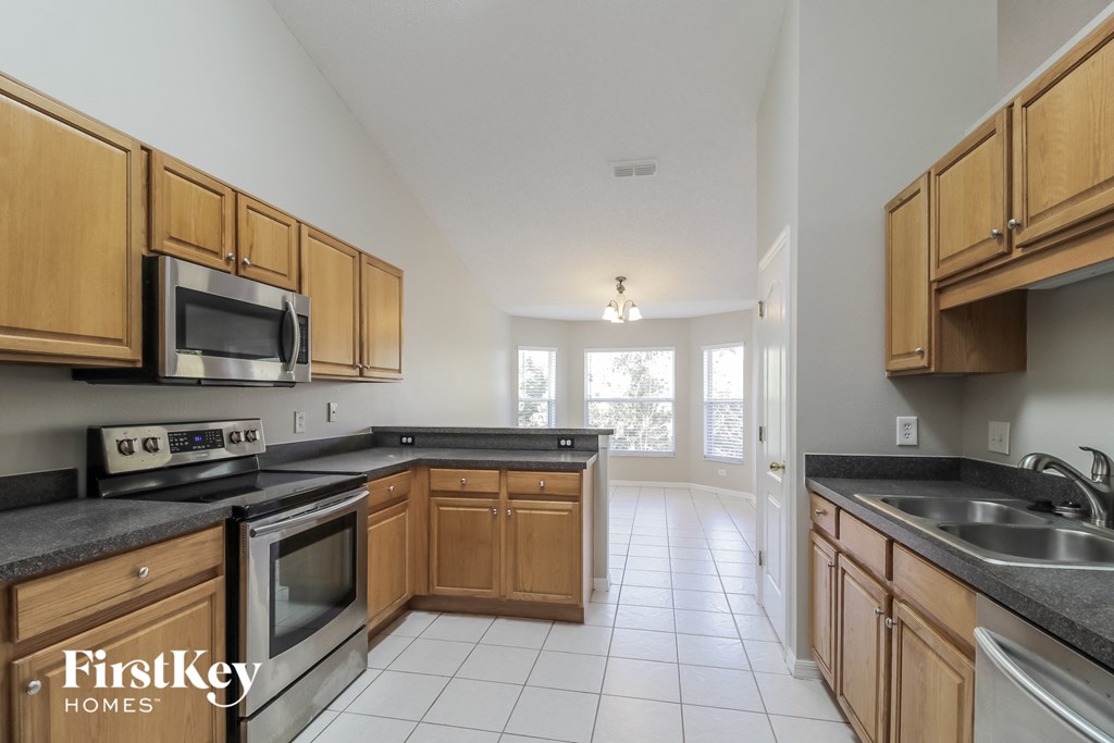 A kitchen with wooden cabinets and a stainless steel oven.