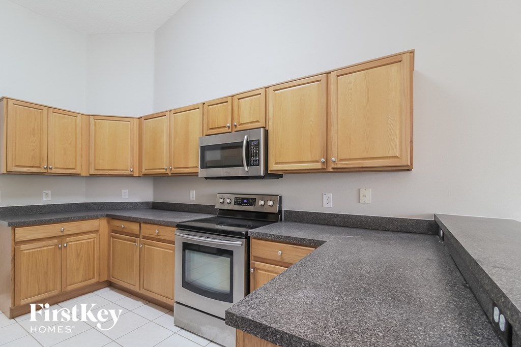 A kitchen with wooden cabinets and a granite countertop.