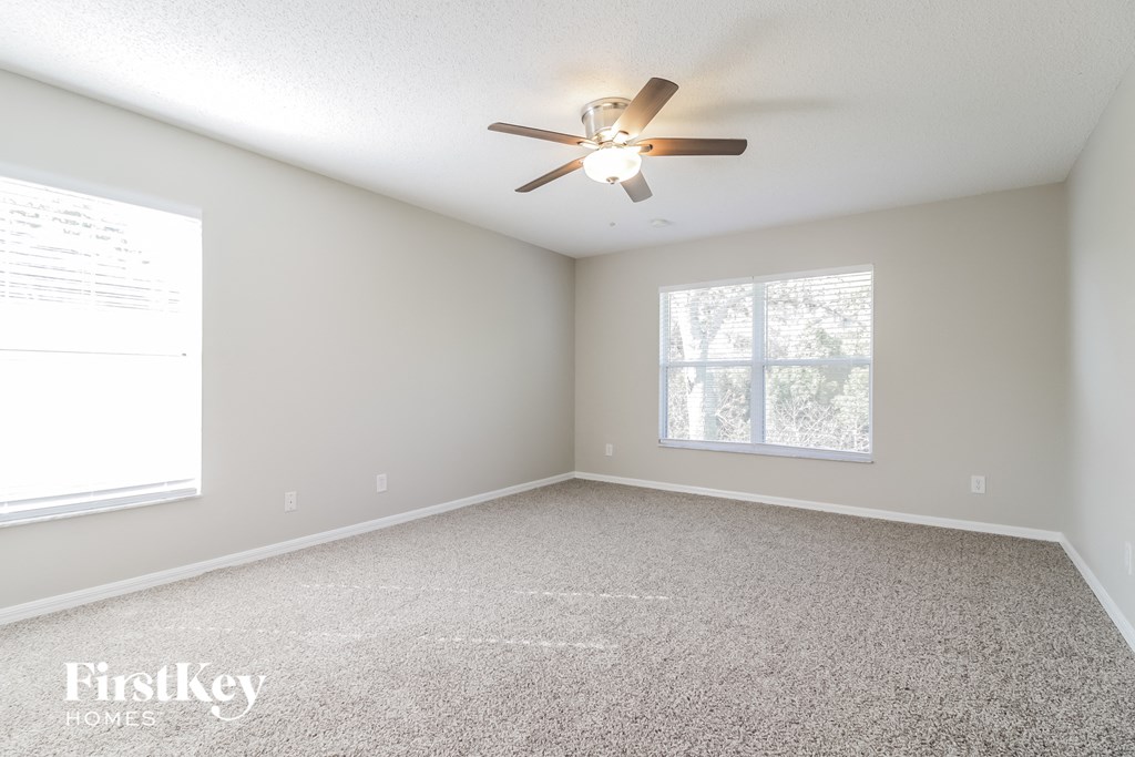 A room with a ceiling fan and a window.