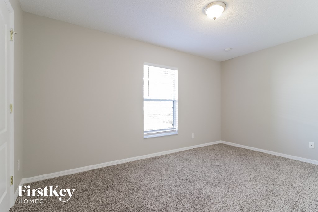 A room with a carpeted floor and a window.