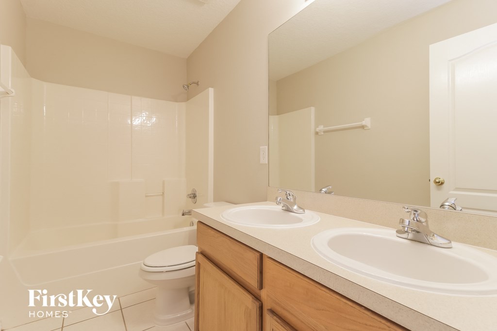 A bathroom with a white toilet, a white sink, and a white bathtub.
