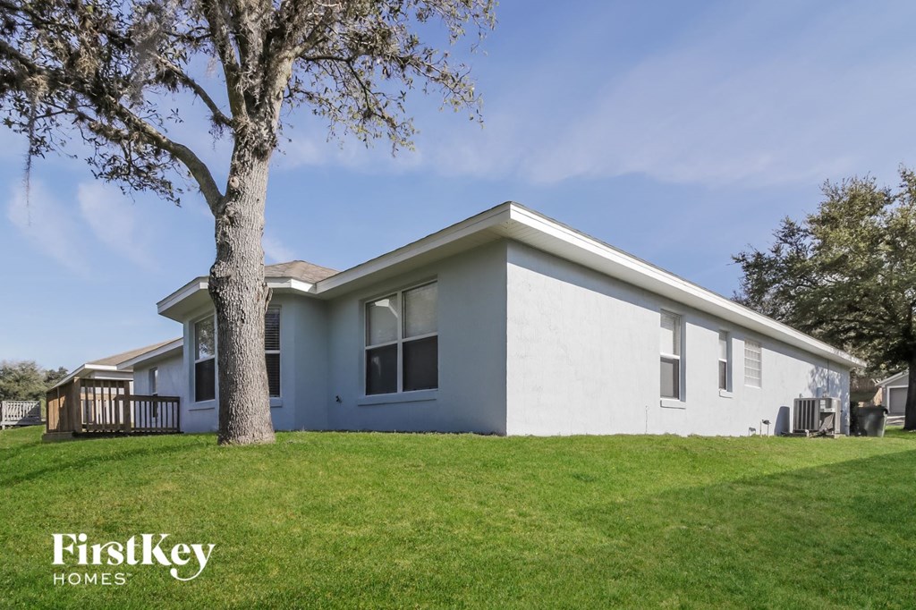 A white house with a tree in front of it.