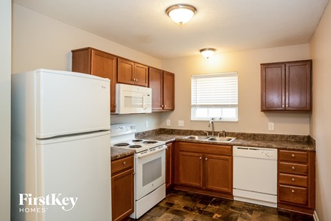 A kitchen with a white fridge and wooden cabinets.