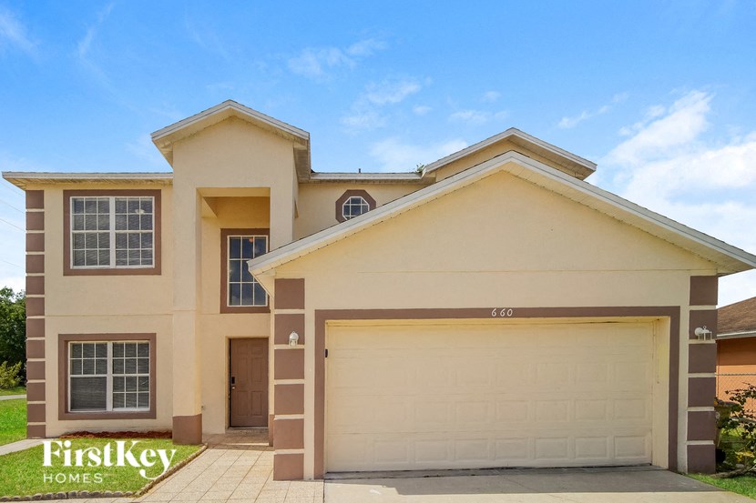 A two-story house with a garage is for sale.