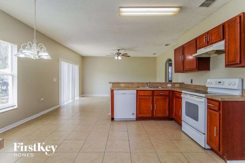 A kitchen with wooden cabinets and a white dishwasher.