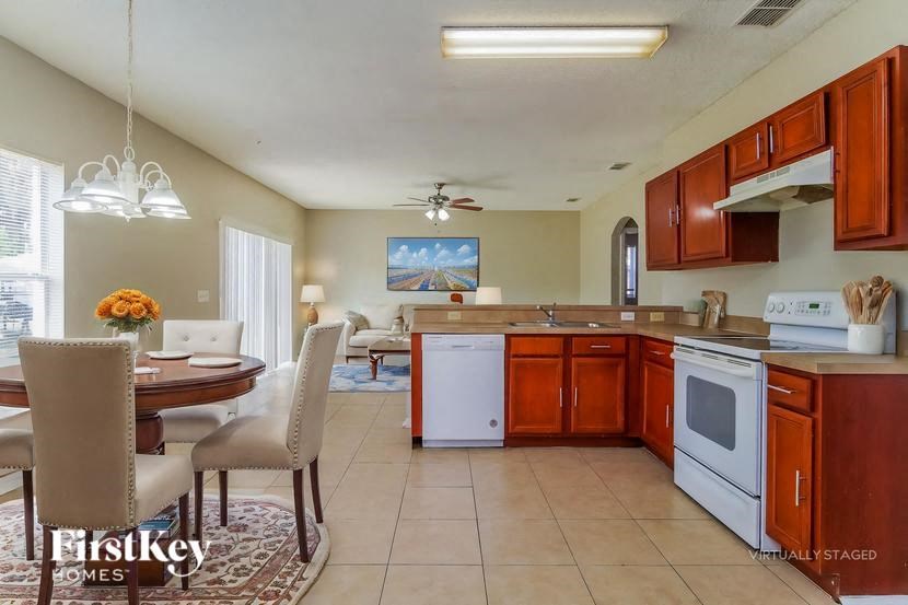 A kitchen with brown cabinets and a white dishwasher.