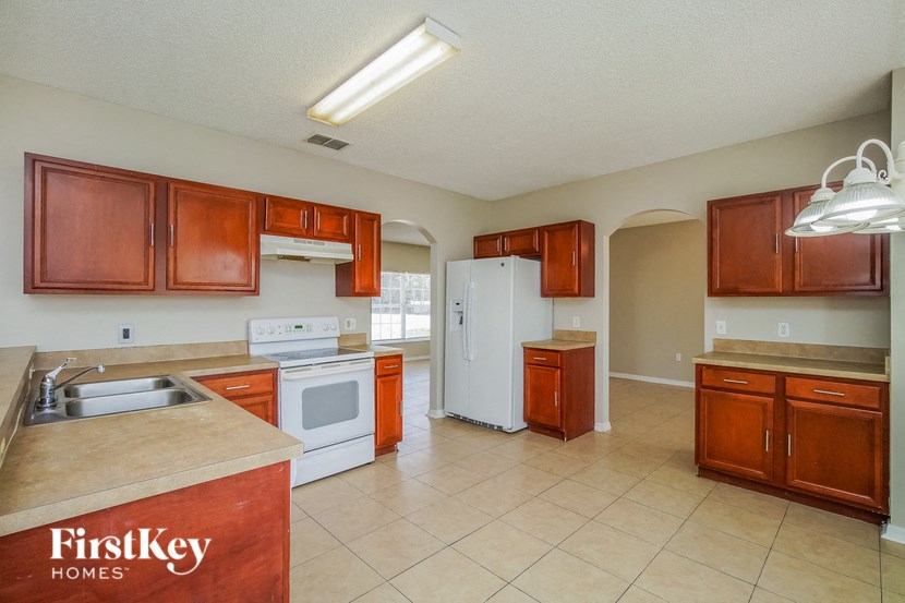 A kitchen with brown cabinets and a white fridge.