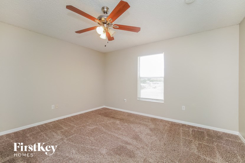 A room with a ceiling fan and a window.