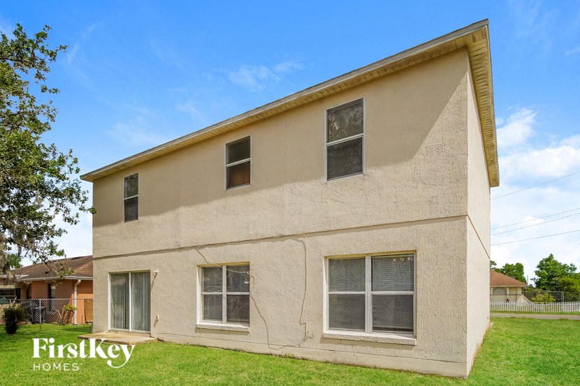 A beige house with the words "FirstKey Homes" on the lawn.