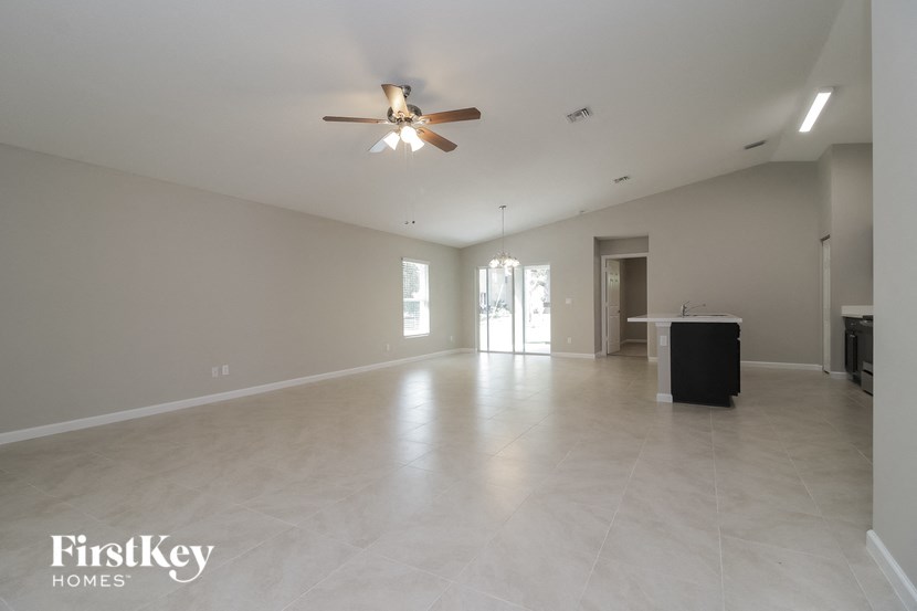 A spacious room with a ceiling fan and a black box on the floor.