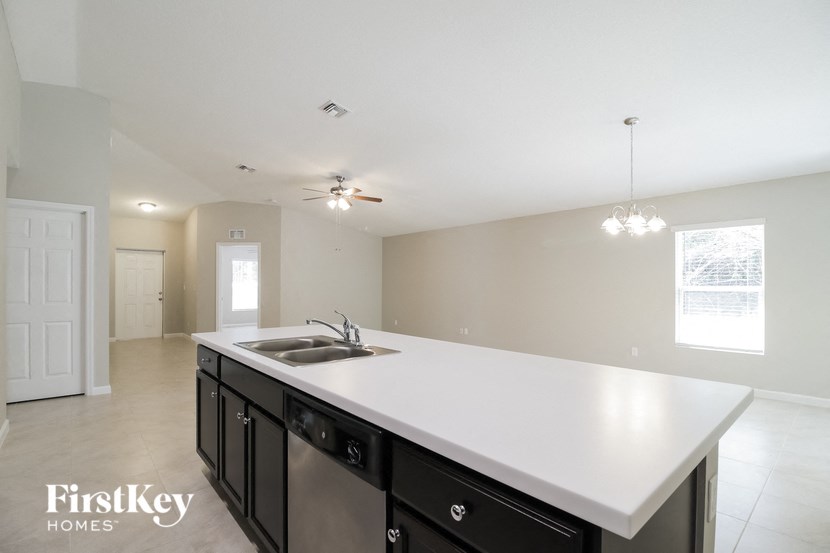 A kitchen with a white counter top and black cabinets.