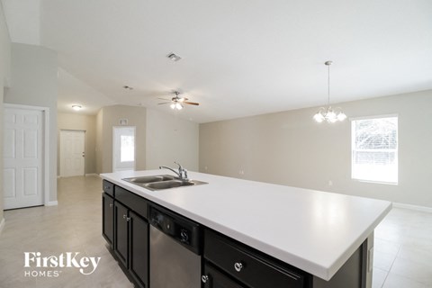 A kitchen with a white counter top and black cabinets.