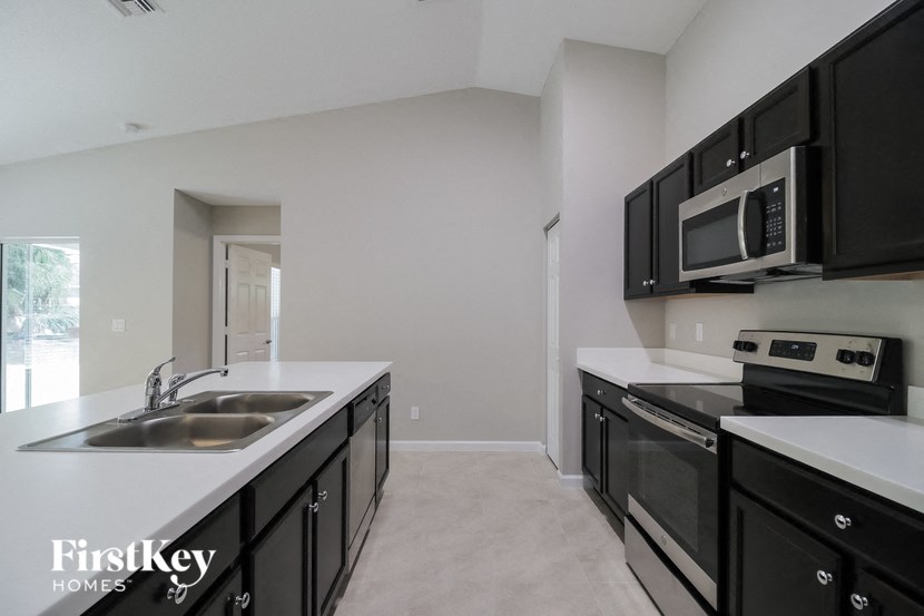 A kitchen with black cabinets and a white counter top.