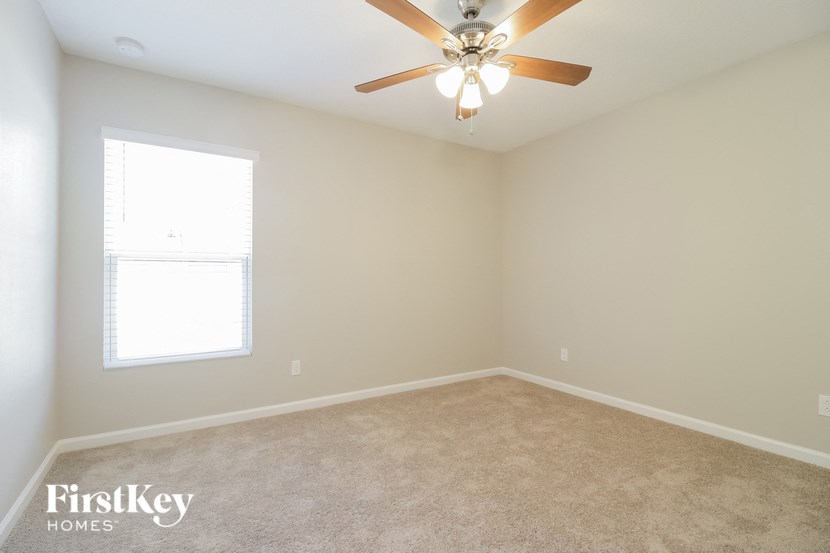 A room with a ceiling fan and a window.
