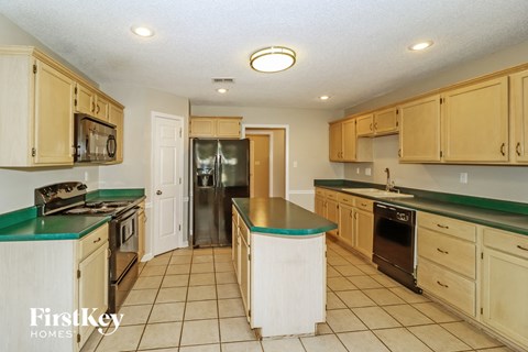 A kitchen with wooden cabinets and a green countertop.