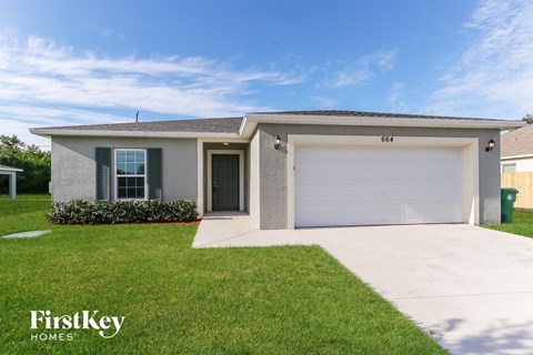 a white house with a lawn and a garage door