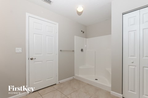 a bathroom with a shower and a toilet and white doors