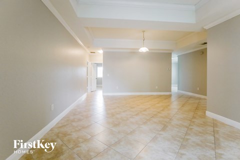 A spacious room with tiled flooring and a single light fixture.