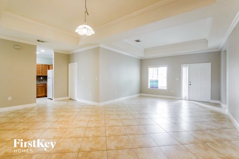 A spacious empty room with a light hanging from the ceiling.