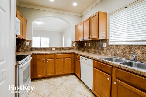 A kitchen with brown cabinets and a white dishwasher.