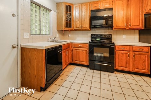 a kitchen with wooden cabinets and black appliances