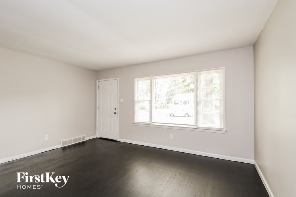 an empty room with white walls and a window and a white door