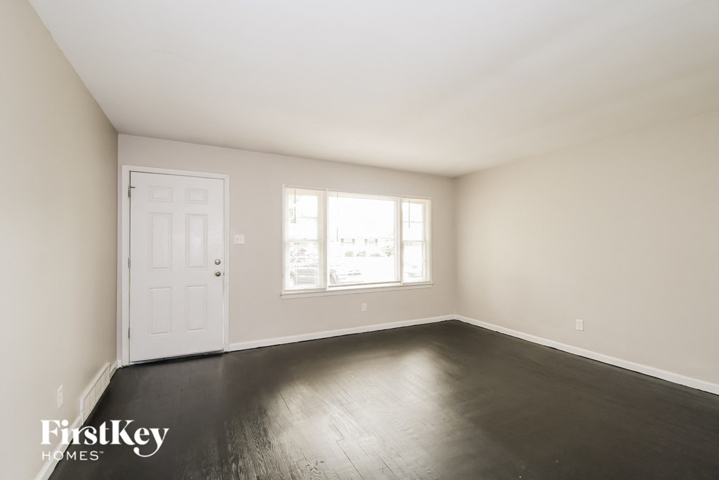 an empty room with white walls and a white door and a window