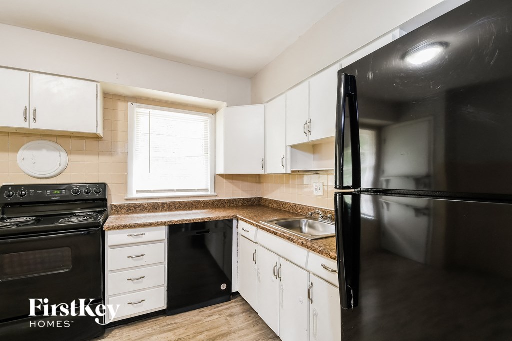 a kitchen with black appliances and white cabinets