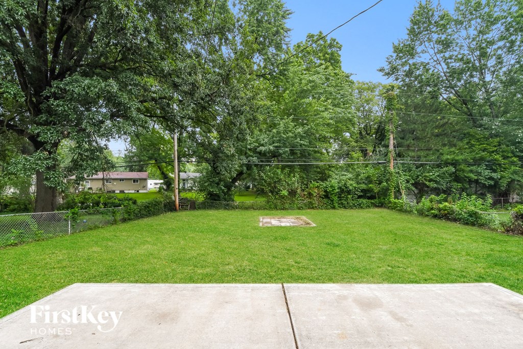 a backyard with a baseball field and a chain link fence