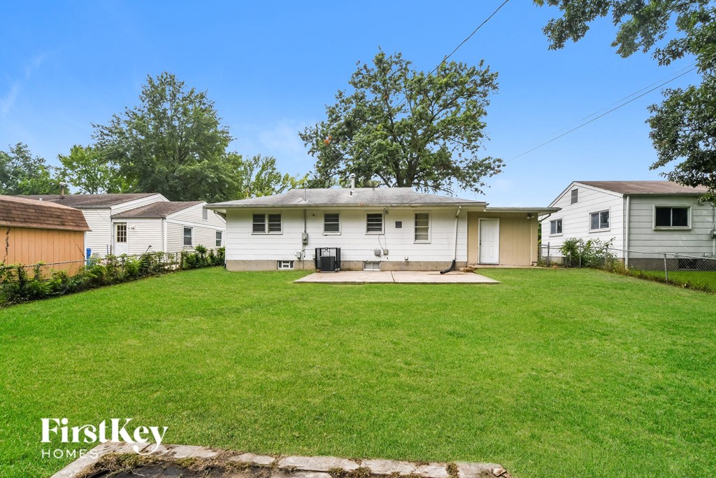 a white house with a green lawn and a backyard