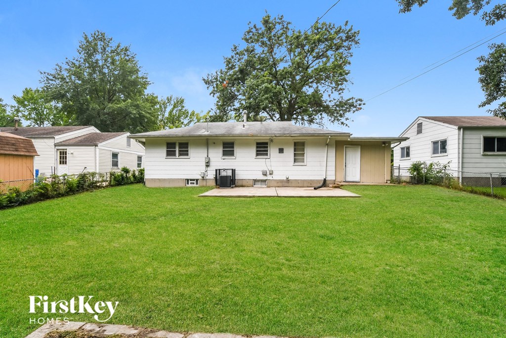 a white house with a green lawn and a backyard