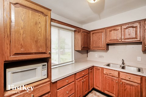 A kitchen with wooden cabinets and a white countertop.