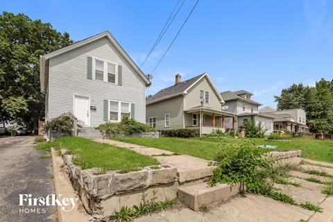 A house with a stone wall in front of it.