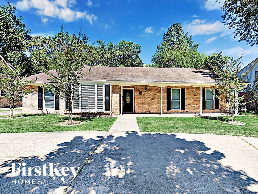 an old brick house with a sidewalk and grass