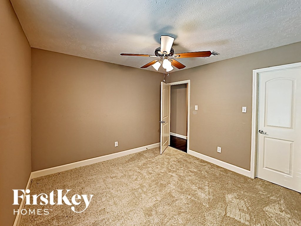 a bedroom with a ceiling fan and a door to a closet