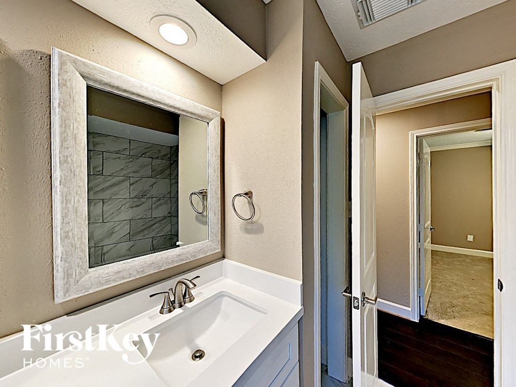 a white bathroom with a sink and a mirror