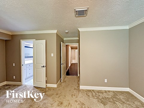 a bedroom with a door to a hallway and a closet