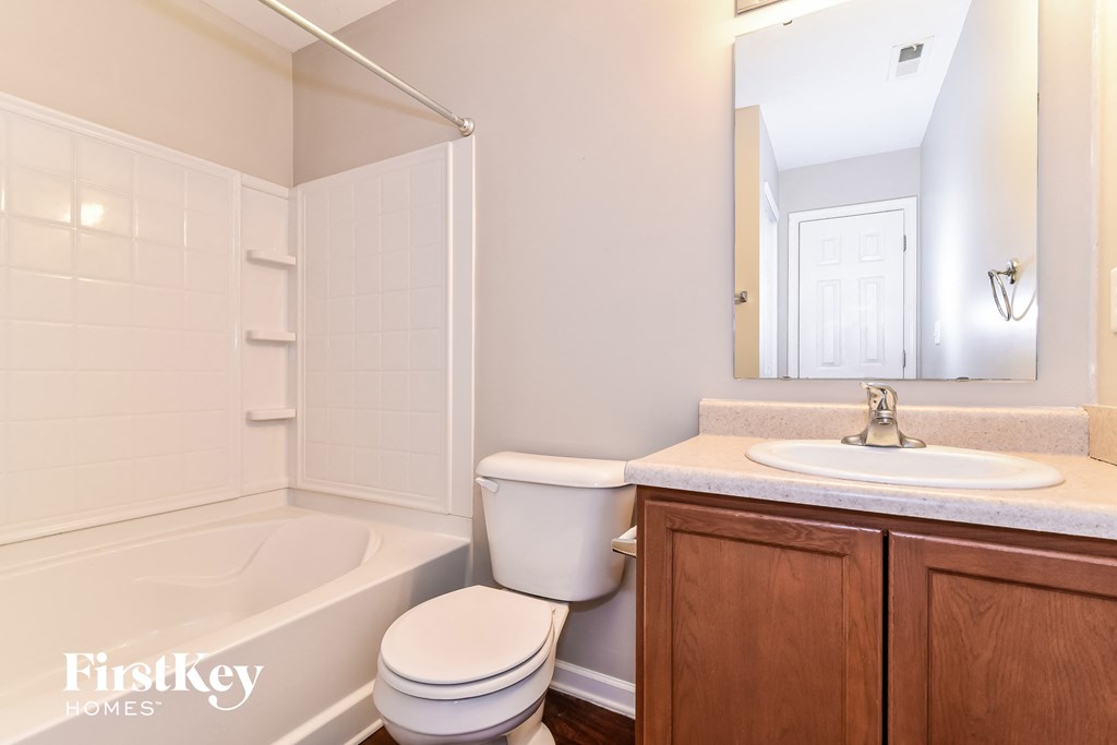 a bathroom with a toilet sink and tub and a mirror