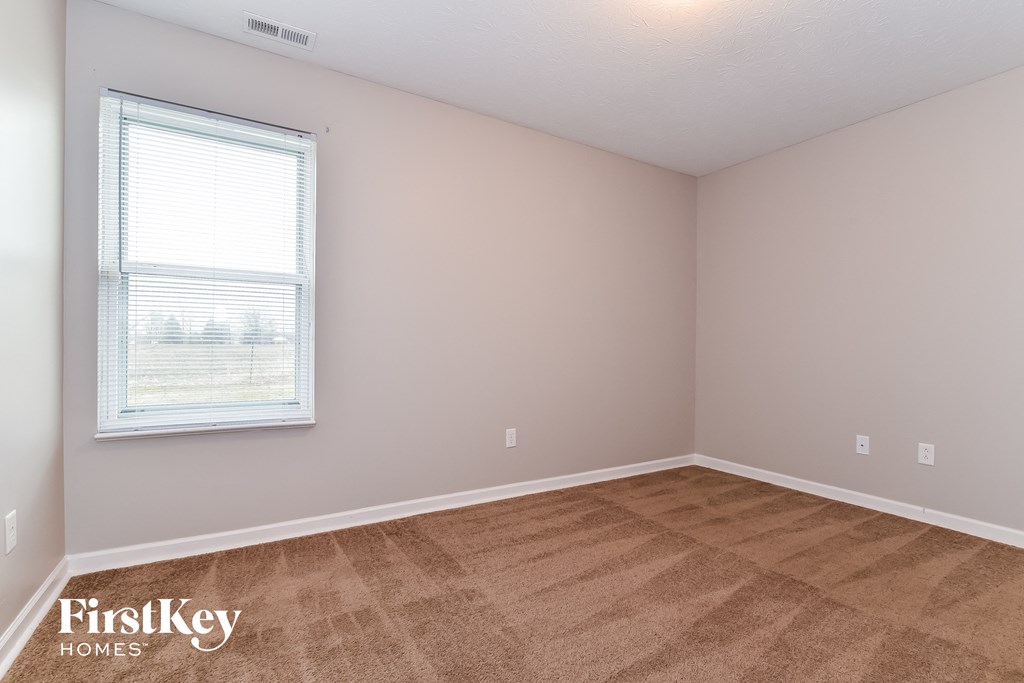 the living room of a home with a carpeted floor and a window