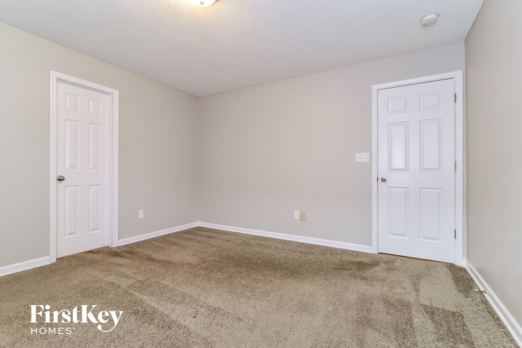 a bedroom with two doors and a carpeted floor