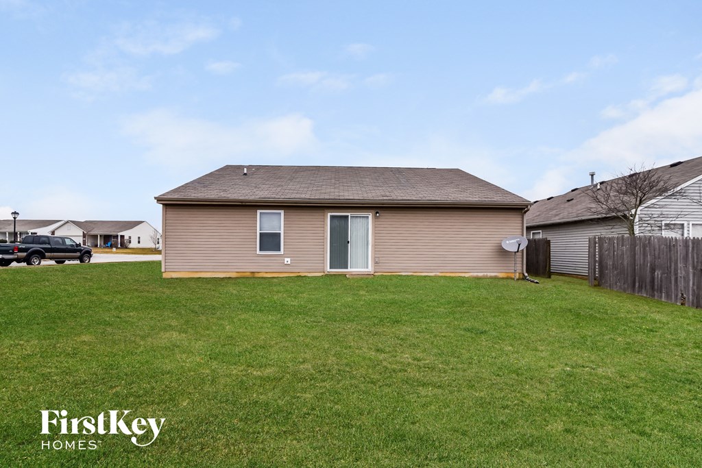 a small brown house in a yard with a green lawn