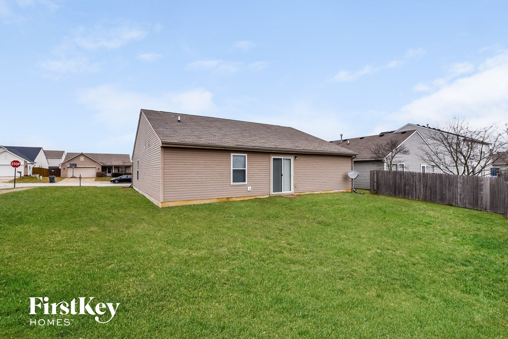 a backyard with a house and a green lawn