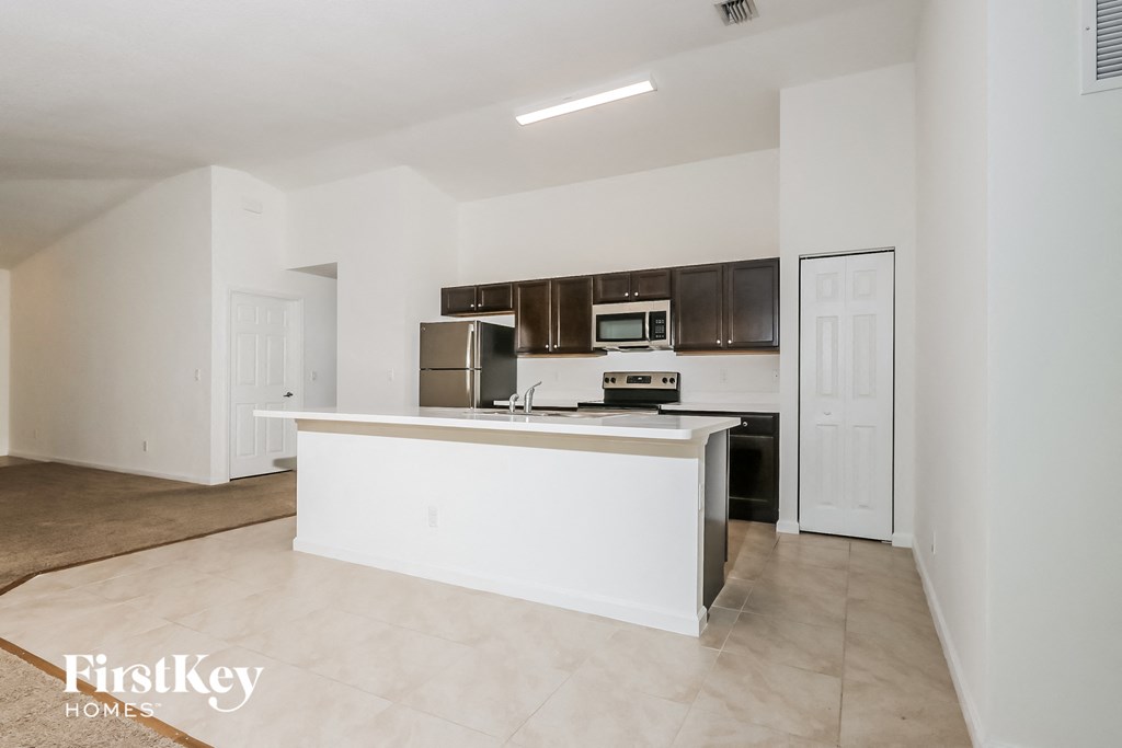 A kitchen with a white island and stainless steel appliances.