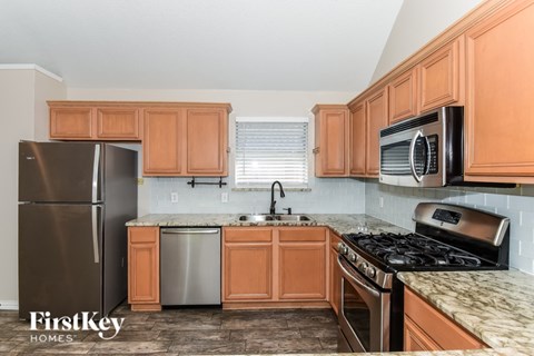 A kitchen with wooden cabinets and a stainless steel refrigerator.