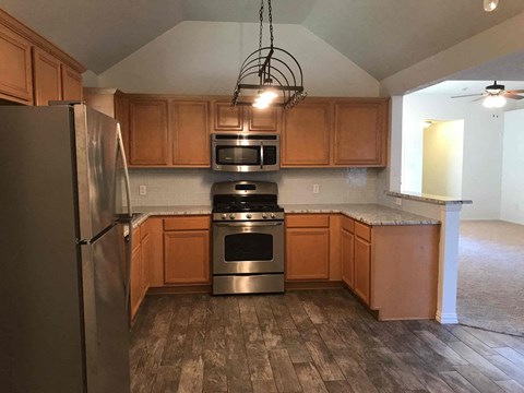 A kitchen with wooden cabinets and stainless steel appliances.