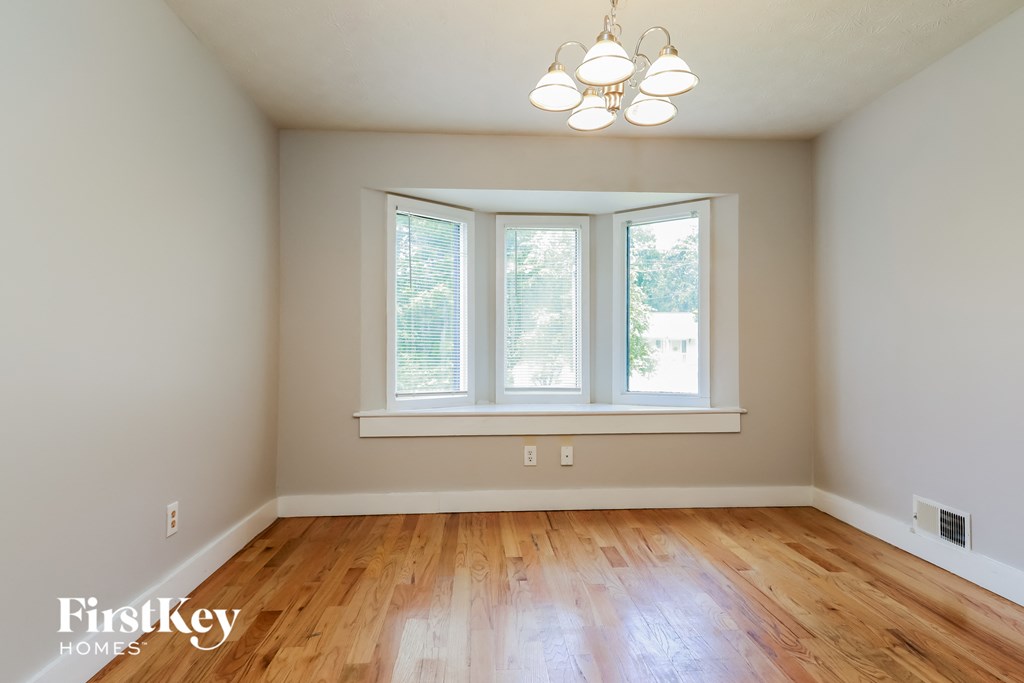 A room with a window and wooden floors.