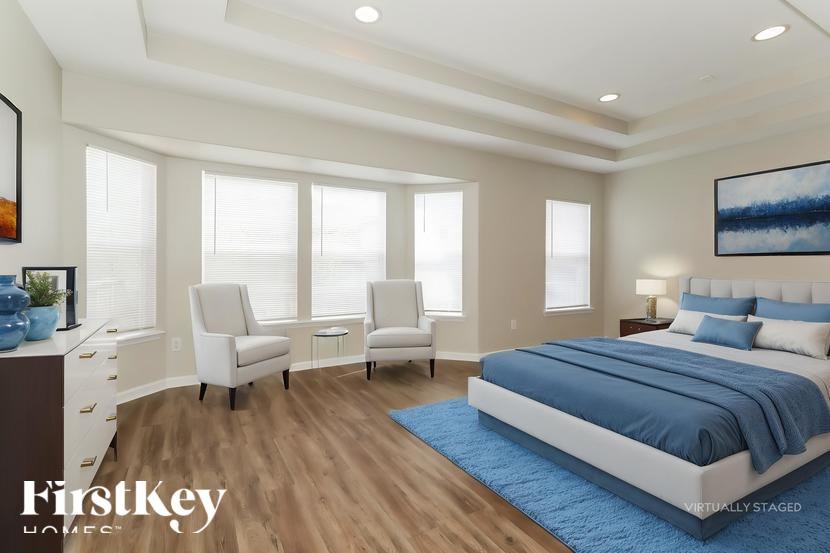 A bedroom with a large bed and a painting on the wall.